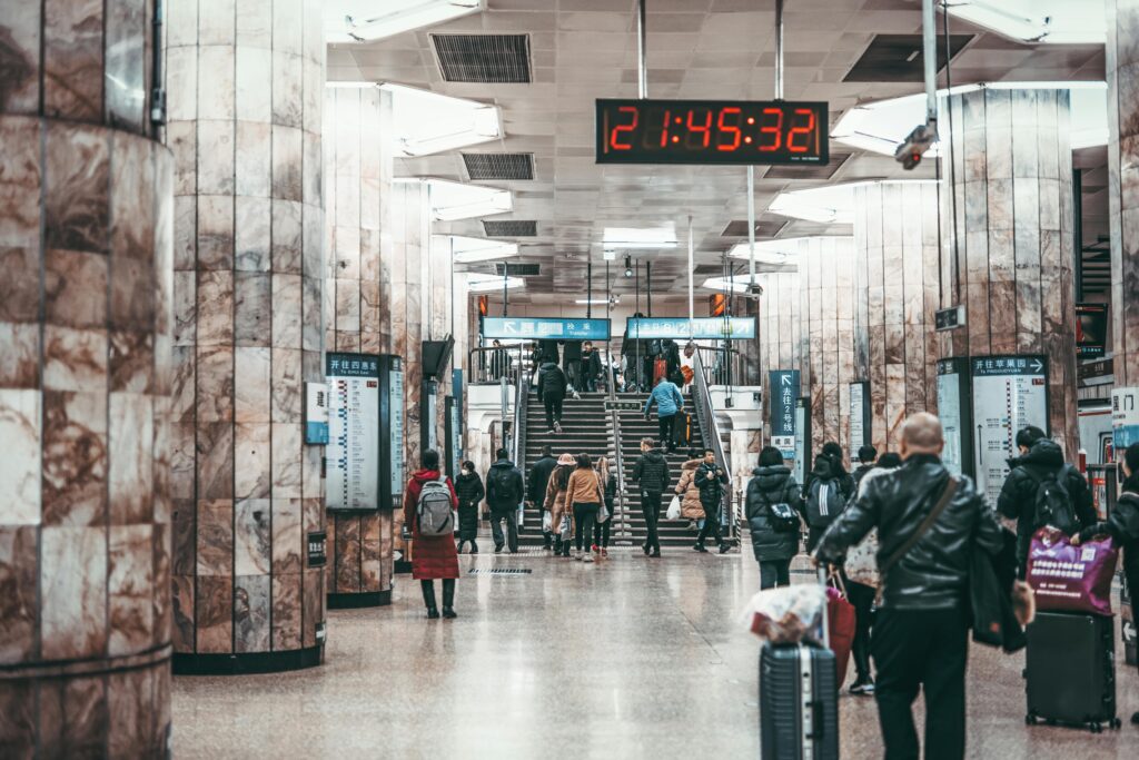 Nighttime scene at a busy Beijing subway station with commuters and vibrant atmosphere.