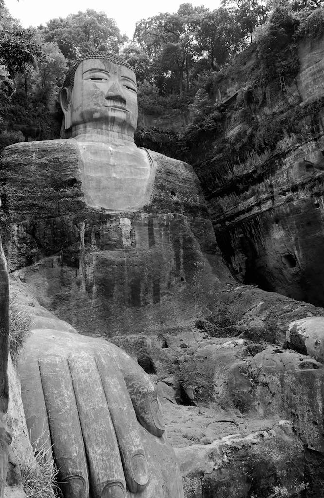 Black and white image showcasing the Leshan Giant Buddha carved into a cliff in China.