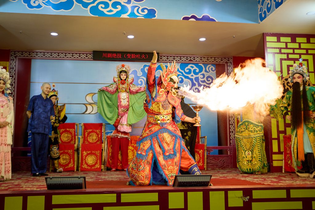 Dramatic Sichuan Opera stage performance featuring colorful costumes and fire-breathing act.