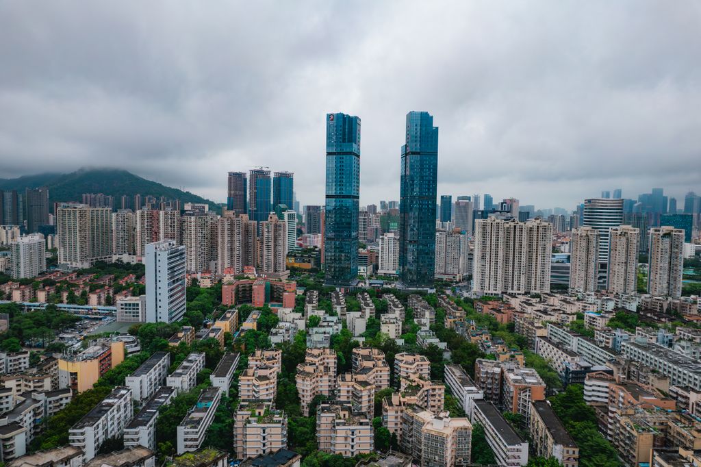 Aerial view of Shenzhen's modern skyscrapers and urban landscape under cloudy skies.
